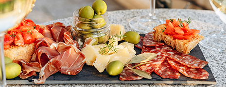 Photo d'une Planche apéritive avec des olives,du parmesan, de la charcuterie et des tartines de pains à la tomates