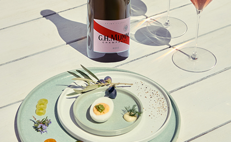 Mumm Rosé sur une table avec un plat